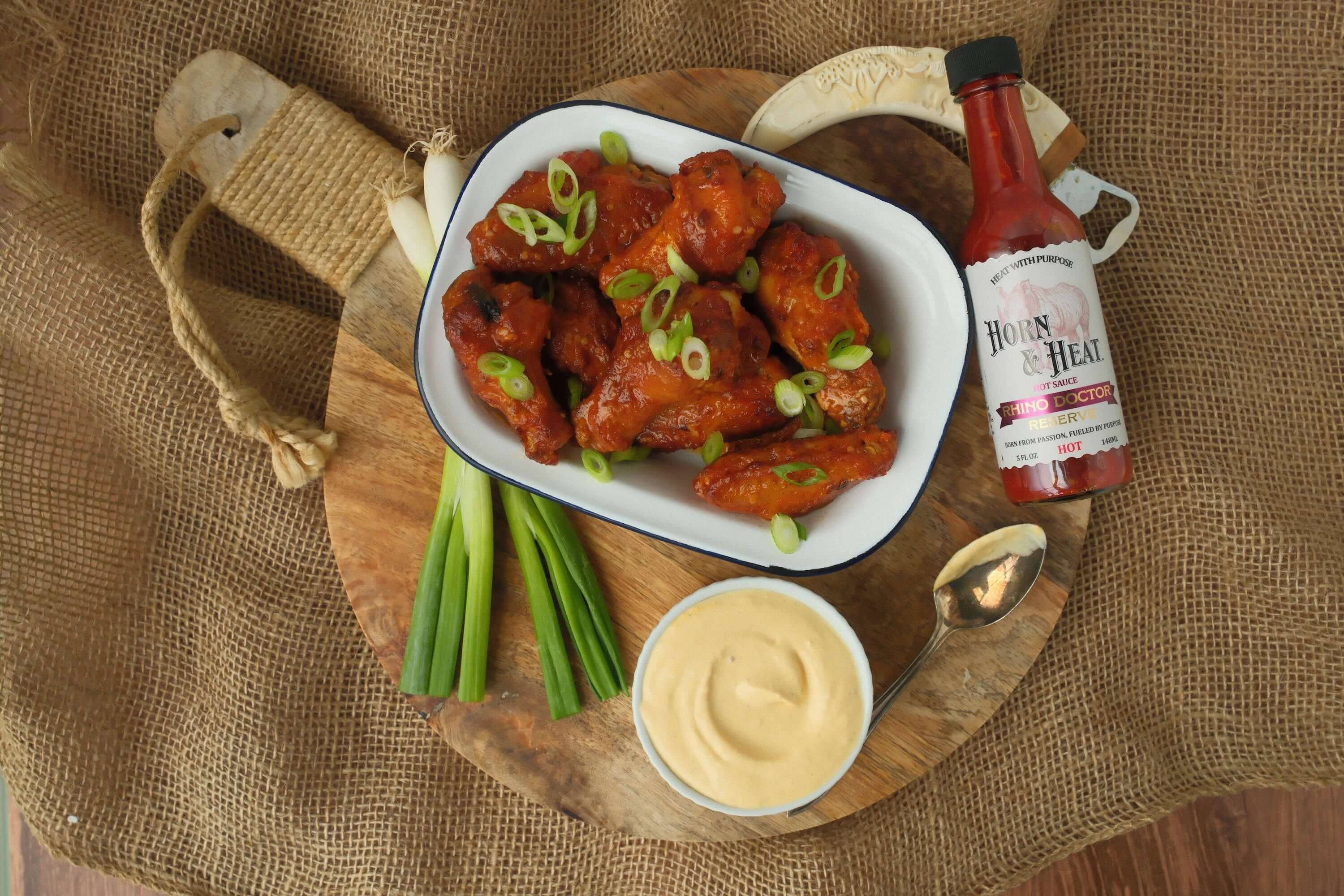 Horn & Heat Chicken Wings with Rhino Doctor Reserve Garlic Butter served with green onions and dipping sauce.